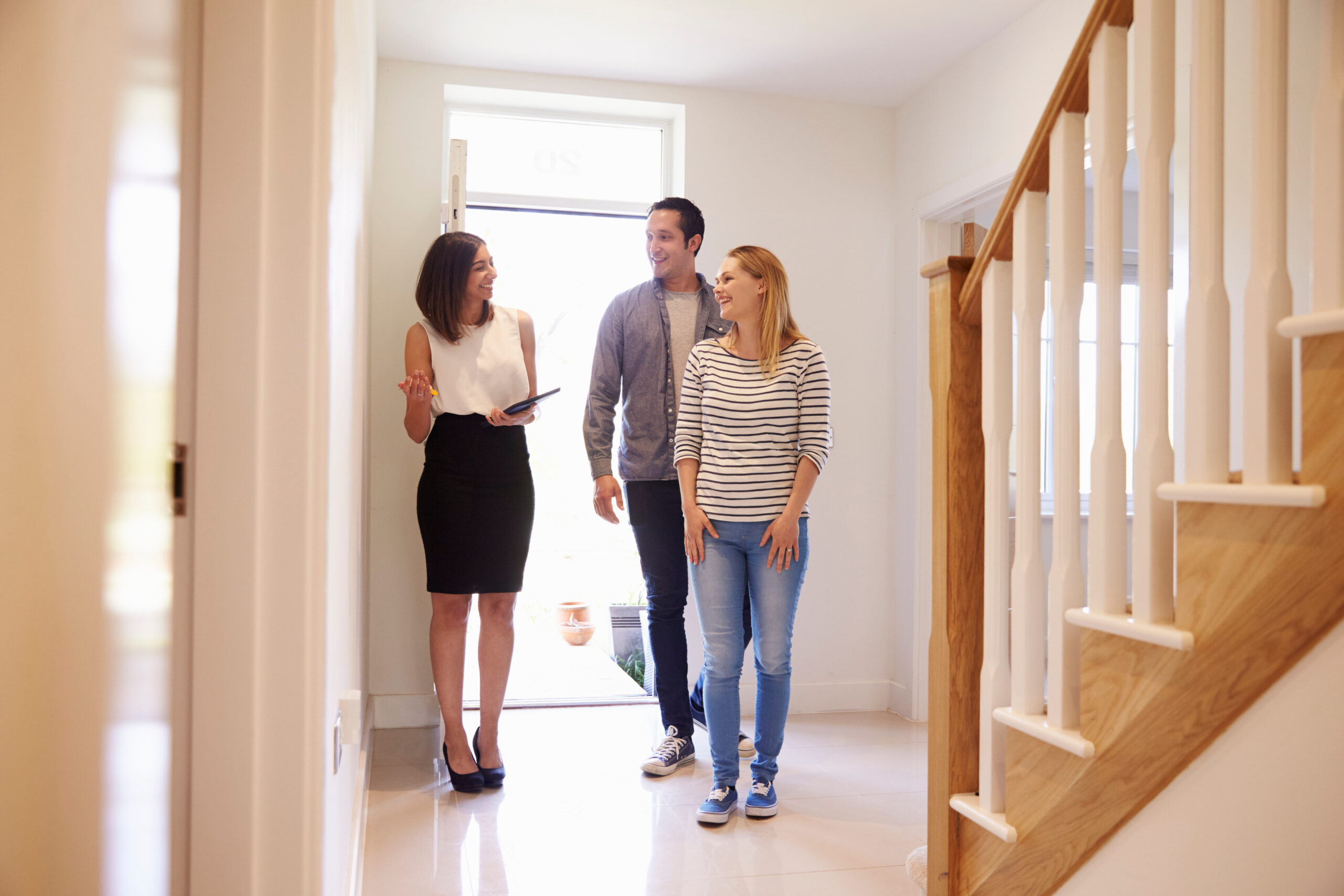 Estate agent showing a couple around a bright home, reflecting property valuation advice and selling guidance for homeowners in Westbury.