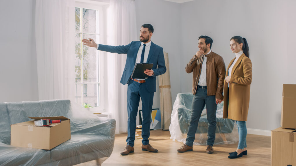 Estate agent showing a couple around a bright property, reflecting selling advice and local market guidance for homeowners in Aberdeen.