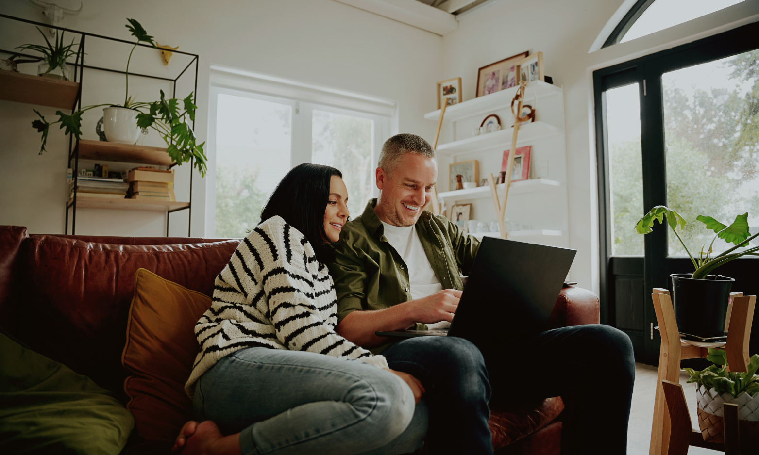 Couple using a laptop at home while searching for their first property in Chelmsford.