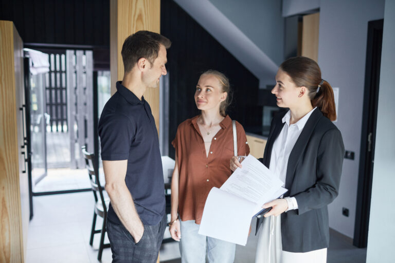 Property investors discussing a home purchase with an estate agent during a property viewing in Cardiff.