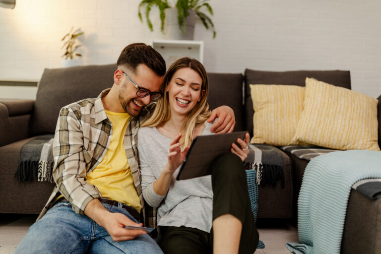 A couple researching homes together on a tablet while planning a move to Springfield CM1 in Chelmsford.