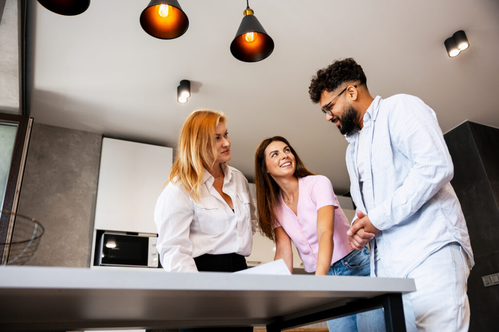 Estate agent discussing property details with a couple during a home valuation in Stoke-on-Trent.