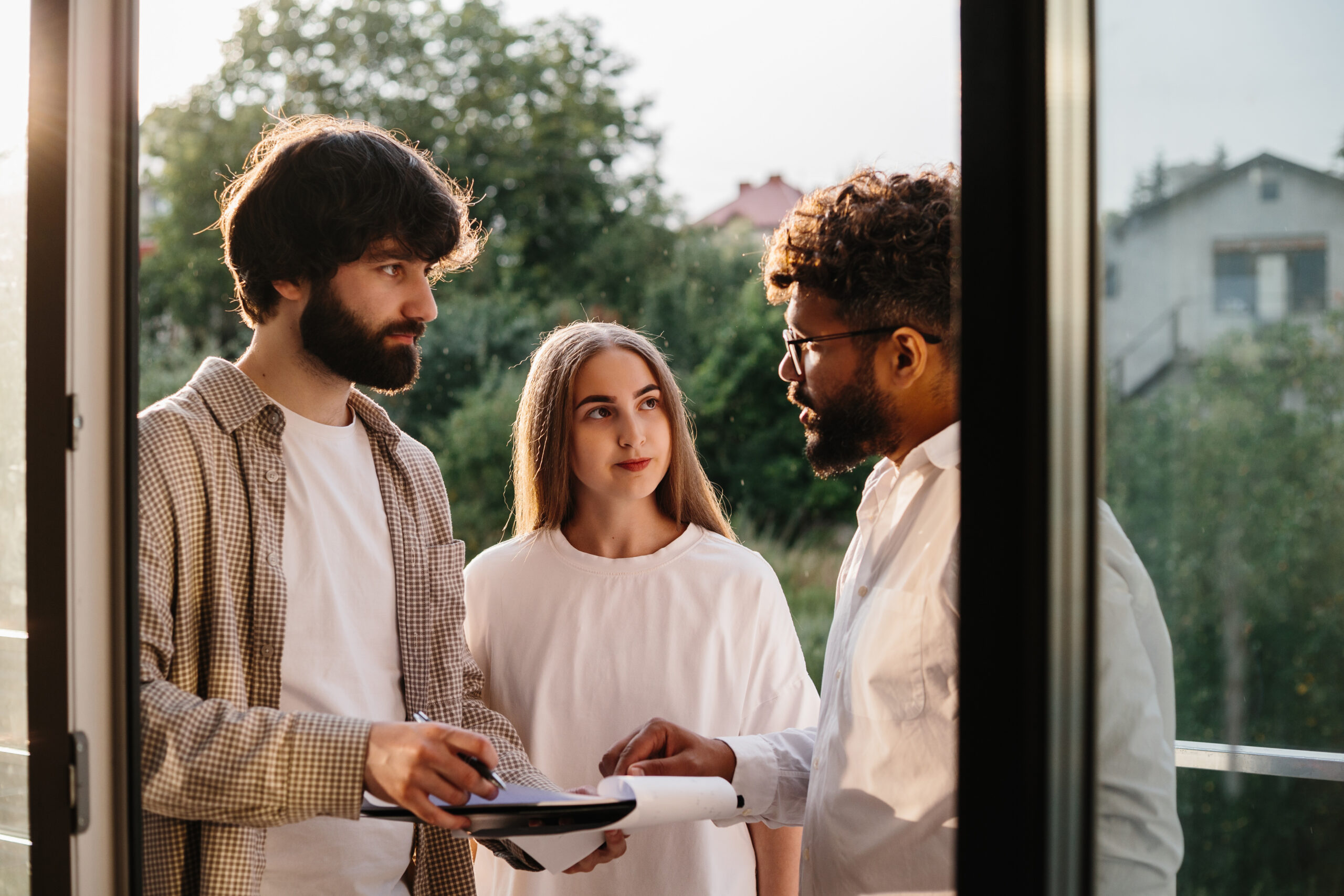 Homeowners discussing property plans with an estate agent during a home visit.