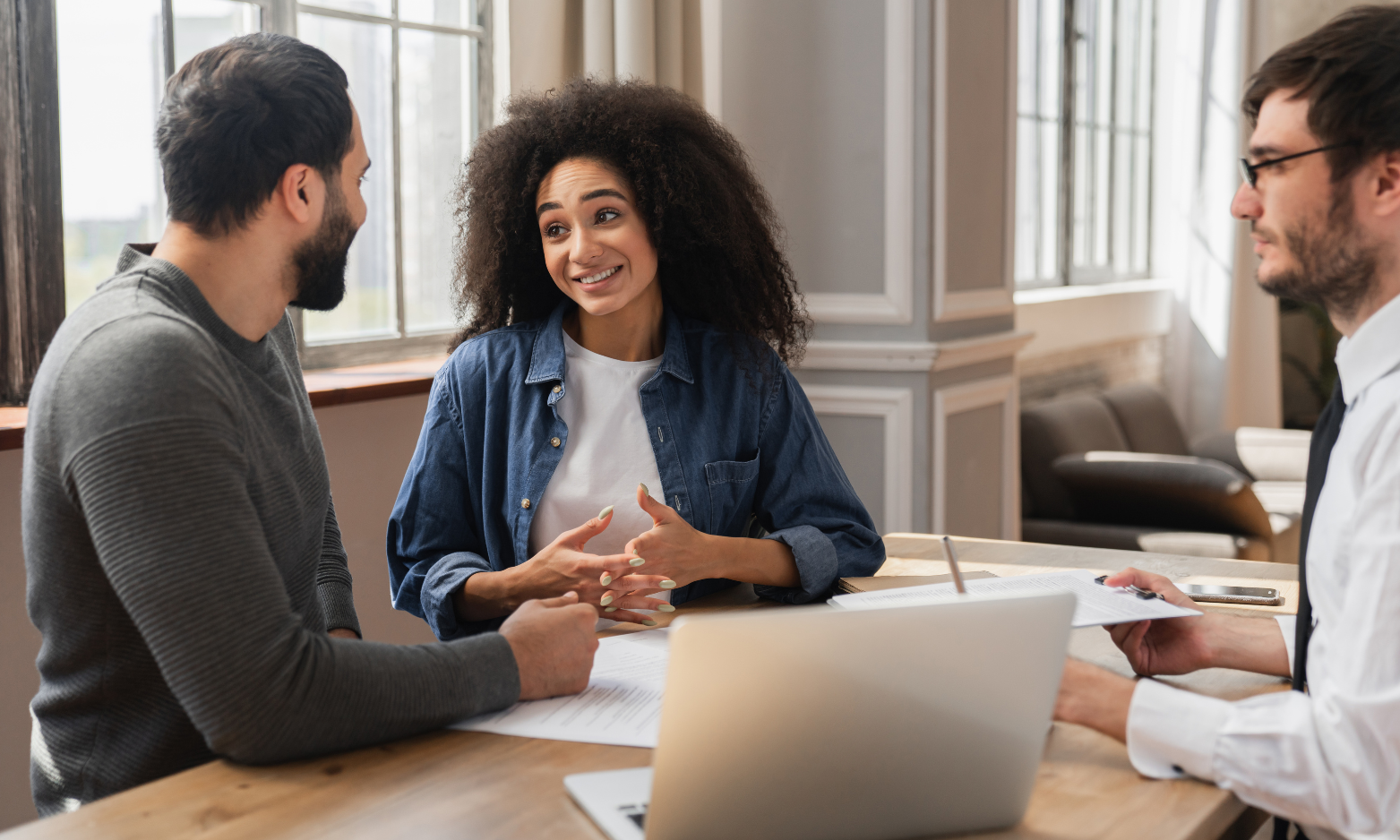 Homeowners discussing their property plans with an estate agent during a meeting.