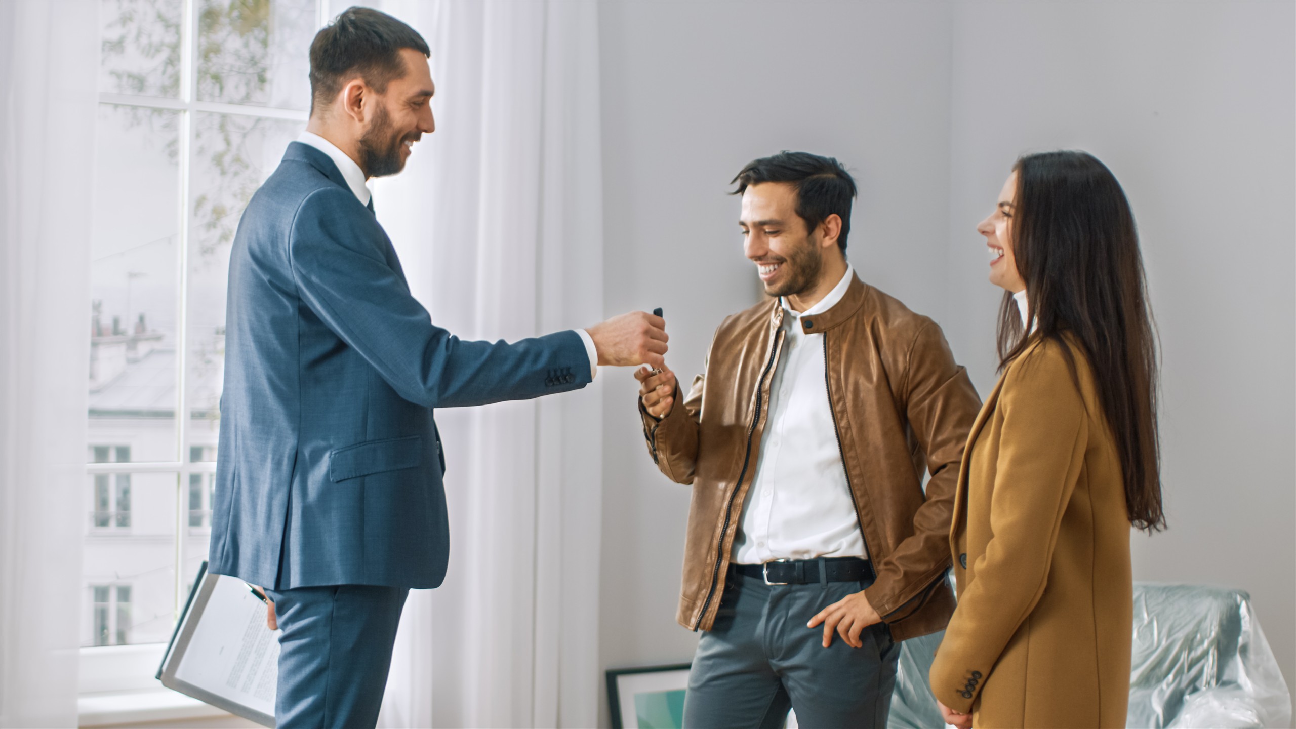 Estate agent handing keys to home buyers