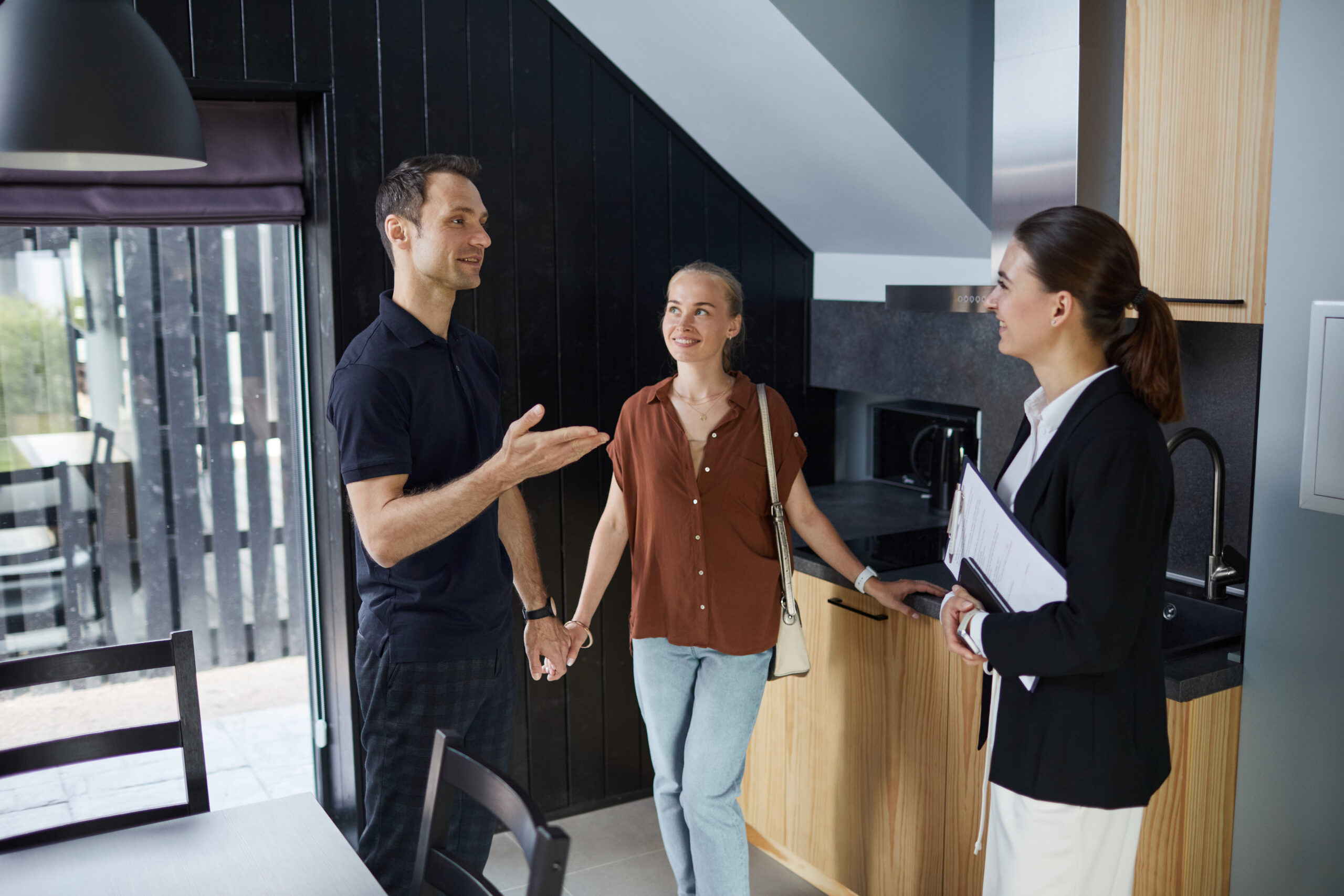 Estate agent showing a couple around a modern property