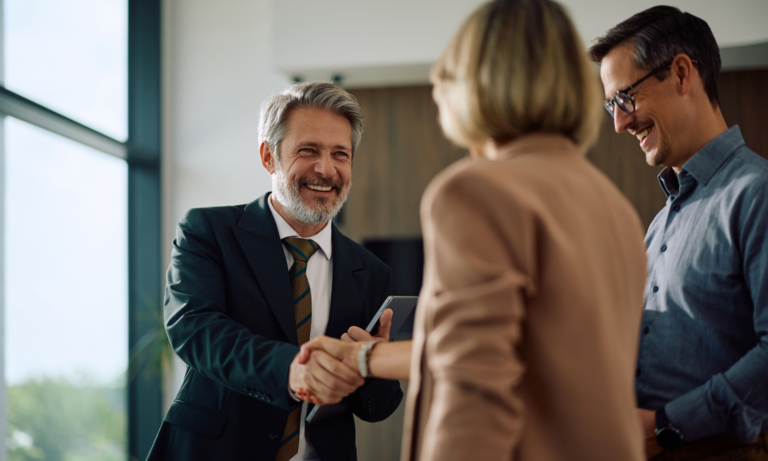 Estate agent shaking hands with clients during a property consultation in Chelmsford.