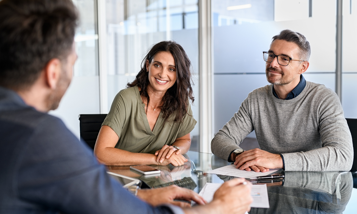 Couple discussing their home sale with a property agent