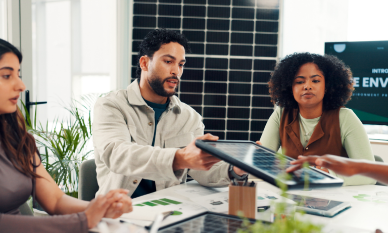 Property professionals discussing home energy improvements beside a solar panel