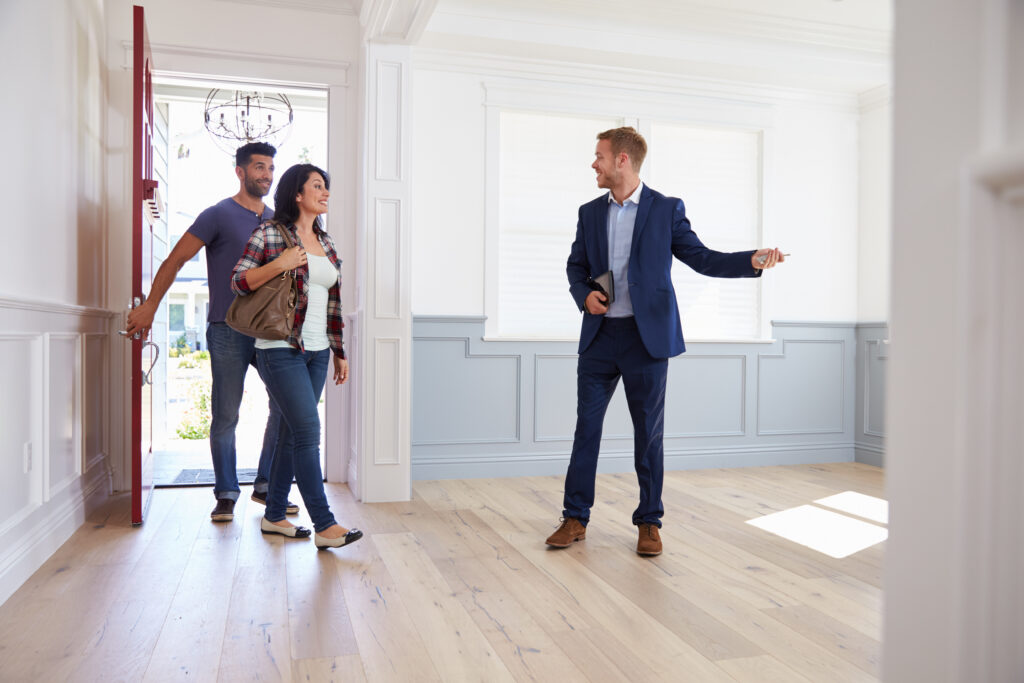 Estate agent welcoming prospective tenants into a bright residential property during a viewing in Birmingham.