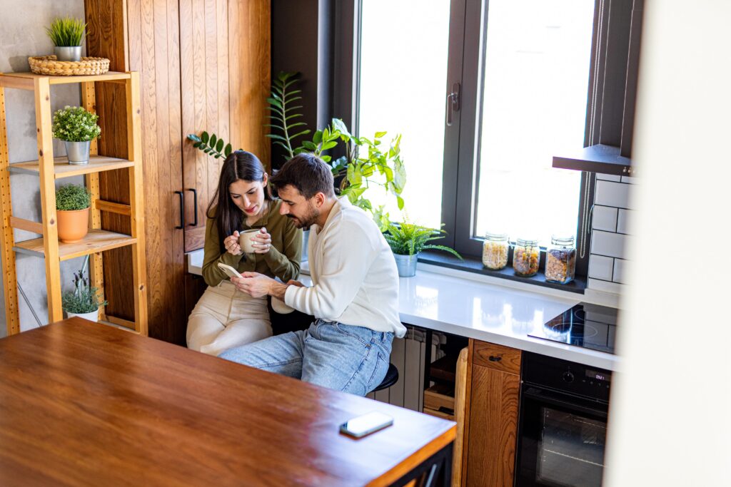 Couple sitting together in a bright wooden kitchen, reflecting home life in Bridge of Allan FK9 near Stirling